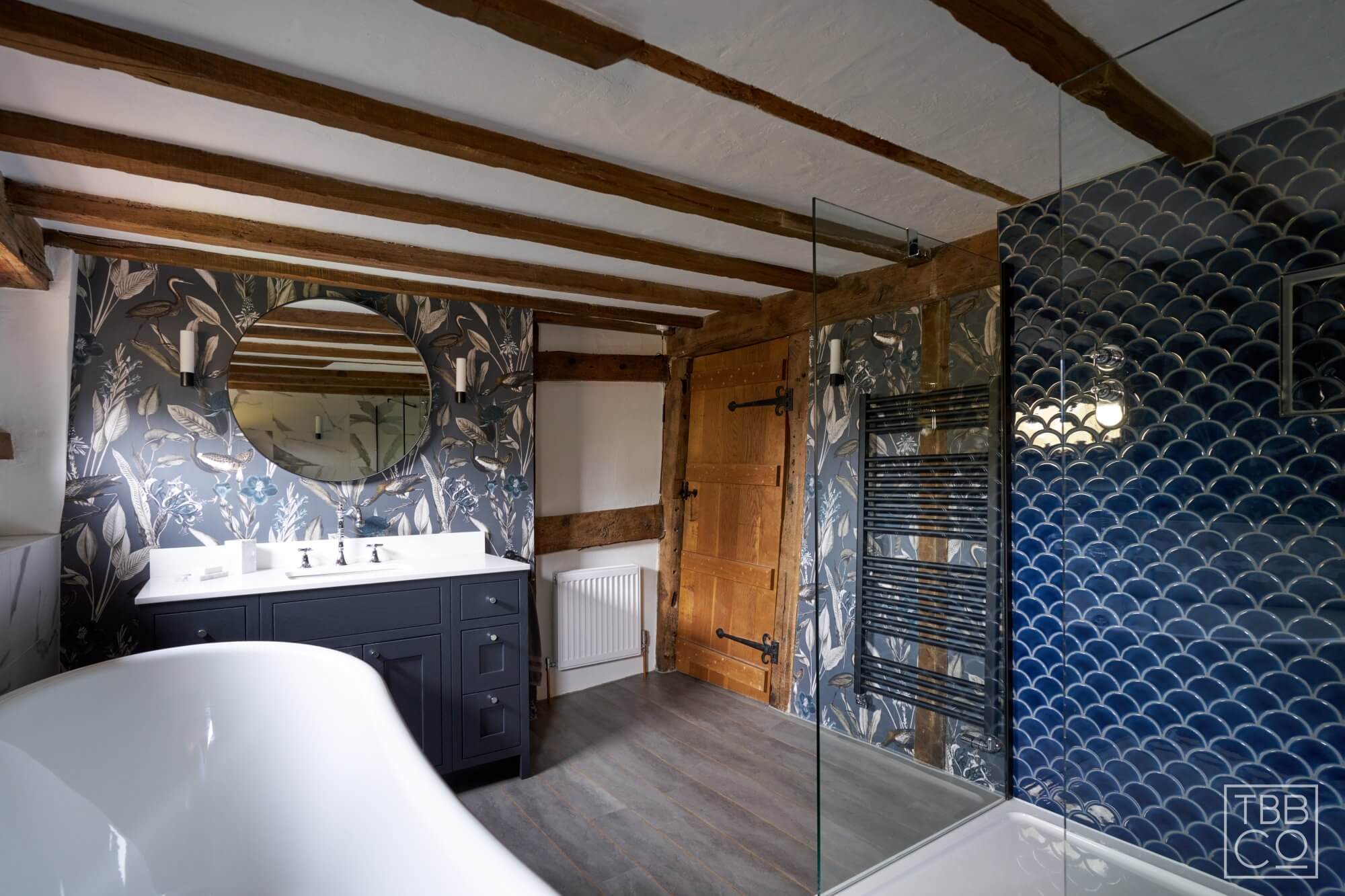 Blue fish tiles in bathroom with black heated towel rail