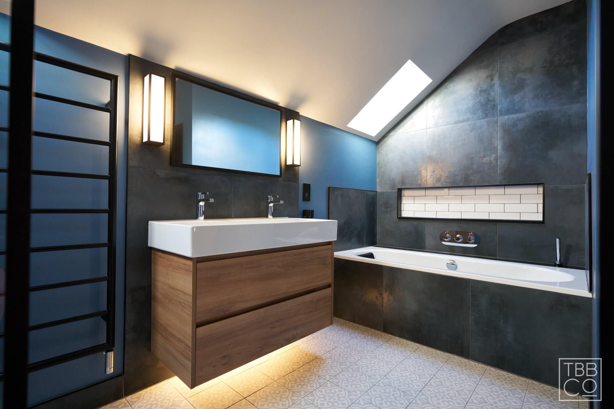 Bathroom design with dark tiles and black taps and shower enclosure